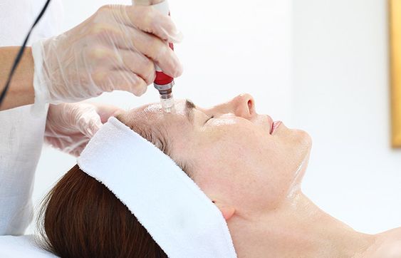 Woman receiving non-invasive skin treatment to improve complexion and texture